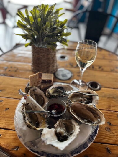 Assiette d’huîtres Glace8 avec vinaigrette et verre de vin au Bacchus