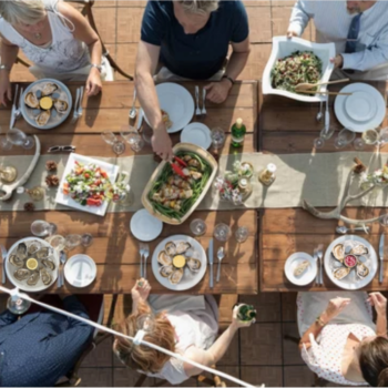 6 personnes assises autour d'une table dégustent des huitres grâce aux assiettes à huîtres en poche de glace Glace8
